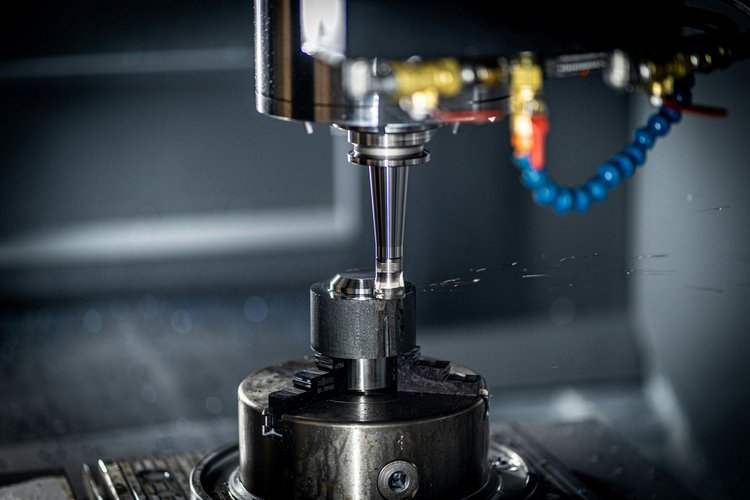 CNC-Maschine bei der präzisen Metallbearbeitung eines Bauteils mit Kühlmittelzufuhr in der Zerspanungstechnik