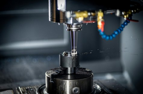 CNC-Maschine bei der präzisen Metallbearbeitung eines Bauteils mit Kühlmittelzufuhr in der Zerspanungstechnik